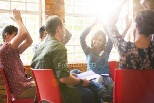 People clapping overhead in group therapy session — Stock Photo