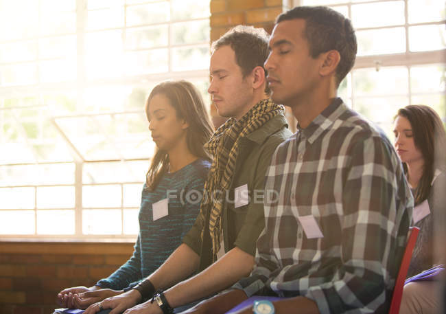 Serene people with eyes closed in audience — Stock Photo
