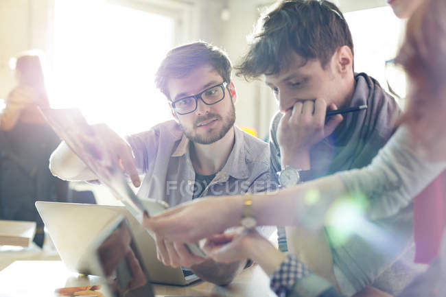 Gente creativa de negocios revisando pruebas en una oficina soleada - foto de stock
