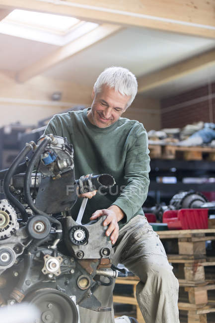 Mechanic rebuilding engine in auto repair shop — Stock Photo