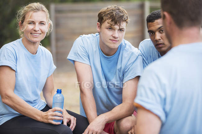 Equipe cansada descansando e bebendo água no acampamento — Fotografia de Stock