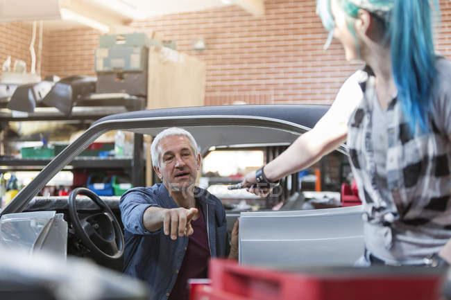Mechaniker greift in Autowerkstatt nach Werkzeug — Stockfoto
