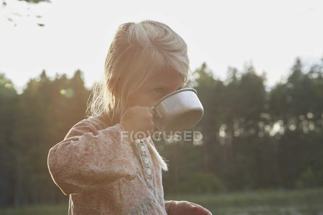 Girl drinking from camping cup — Stock Photo