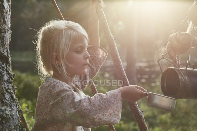 Girl receiving hot soup in sunny woods — Stock Photo