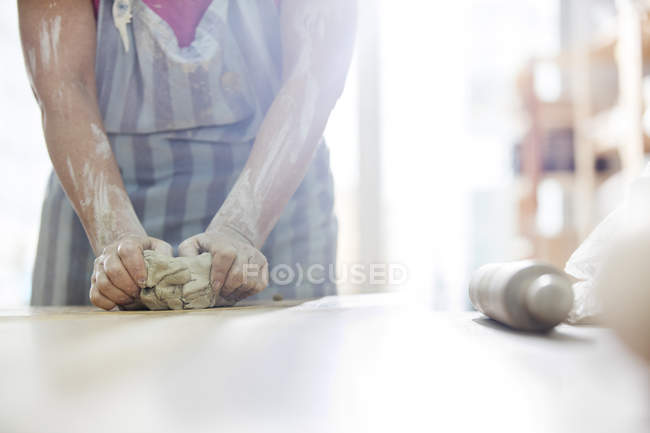 Femme mature moulage de l'argile en atelier de poterie — Photo de stock