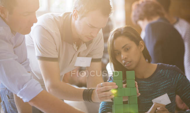 Business people stacking green blocks — Stock Photo