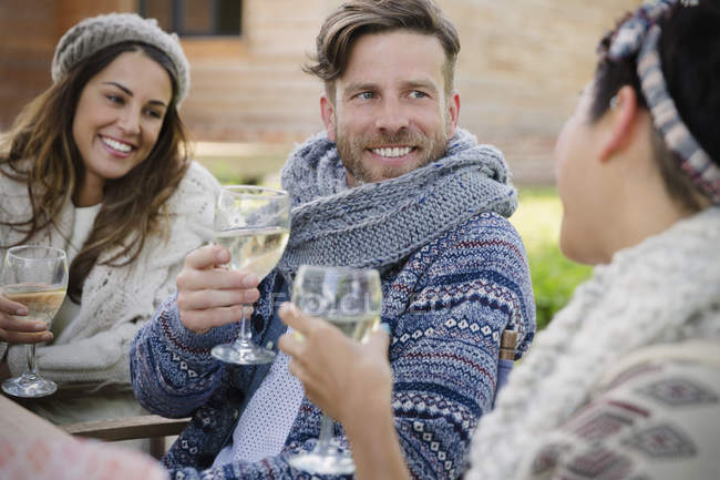 Улыбающиеся друзья пьют вино на террасе — стоковое фото