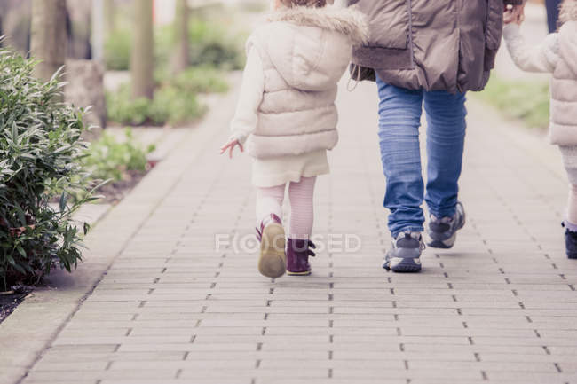 Grandmother and granddaughters walking on stone path — Stock Photo