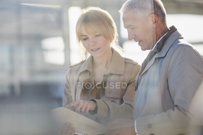Businessman and businesswoman discussing paperwork — Stock Photo
