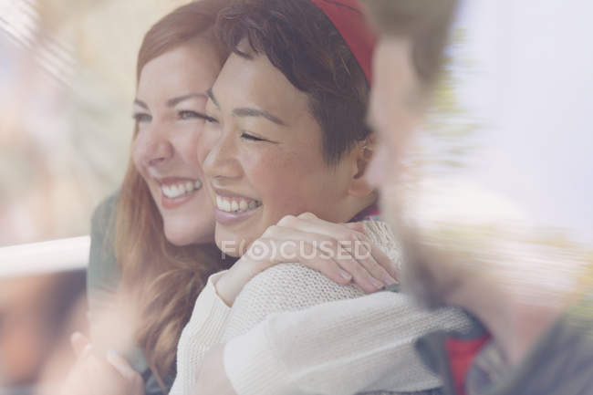 Enthusiastic female friends smiling and hugging — Stock Photo