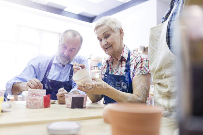 Senior couple painting pottery in studio — Stock Photo