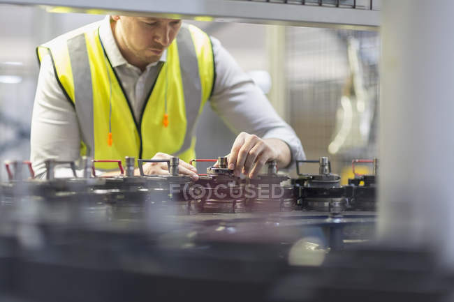 Worker examining machinery in steel factory — Stock Photo
