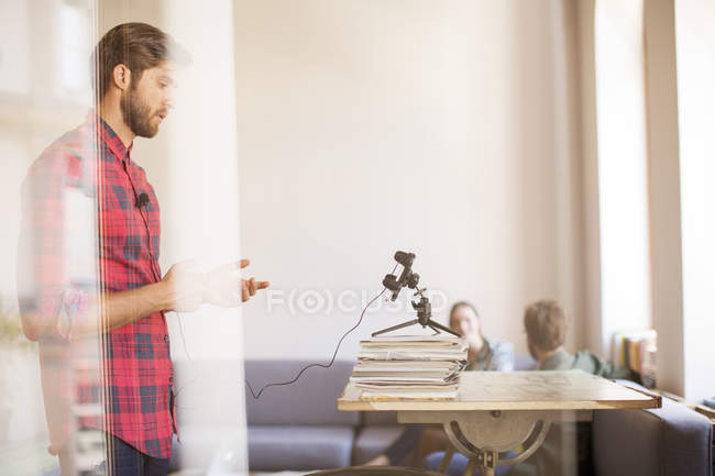 Creative businessman recording video with cell phone in office — Stock Photo