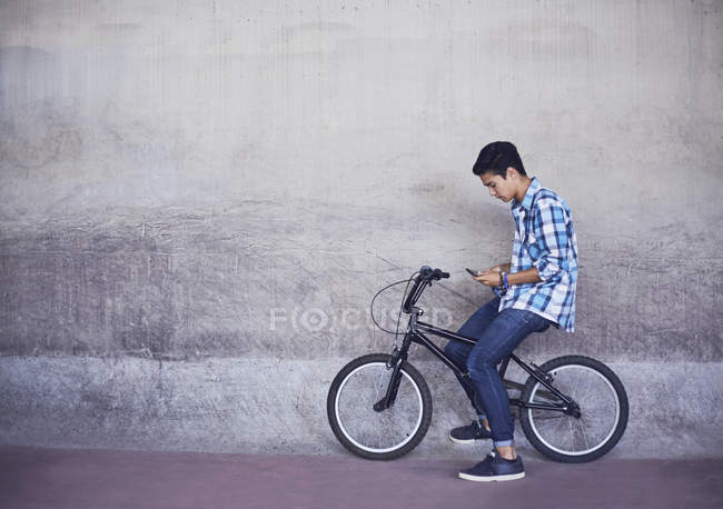 Adolescente ragazzo sms su BMX bicicletta a parete — Foto stock