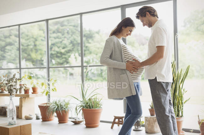 Pregnant couple holding stomach — Stock Photo