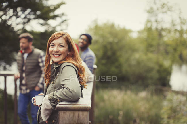 Retrato sorrindo mulher bebendo café com amigos na varanda — Fotografia de Stock