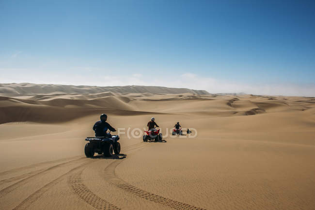 Friends riding quadbikes in sunny desert, Swakopmund, Namibia — Stock Photo
