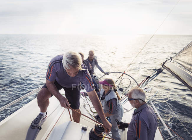 Amigos jubilados navegando en el océano soleado - foto de stock