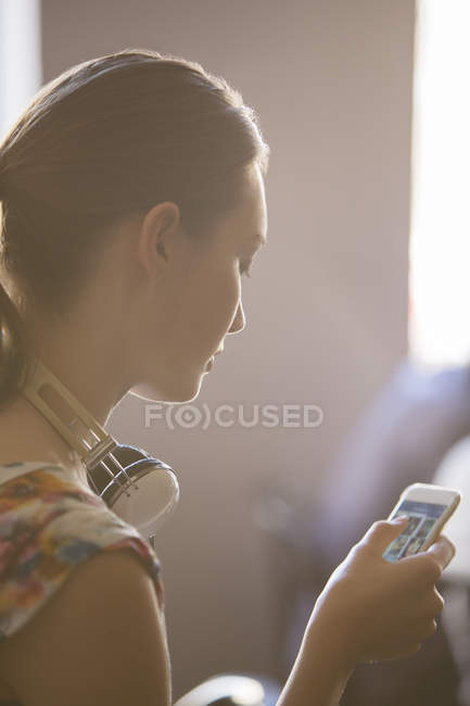 Fechar mulher com fones de ouvido usando telefone celular — Fotografia de Stock