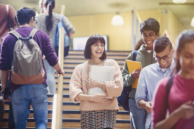 Estudantes universitários sorridentes na escada juntos — Fotografia de Stock