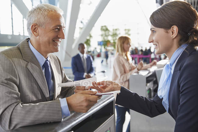 Representante de atendimento ao cliente ajudando empresário no balcão de check-in do aeroporto — Fotografia de Stock