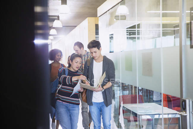 College students discussing homework in corridor — Stock Photo