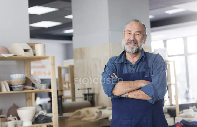 Portrait smiling senior man in pottery studio — Stock Photo