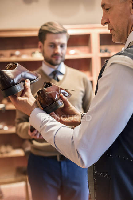 Businessman shopping for dress shoes in menswear shop — Stock Photo