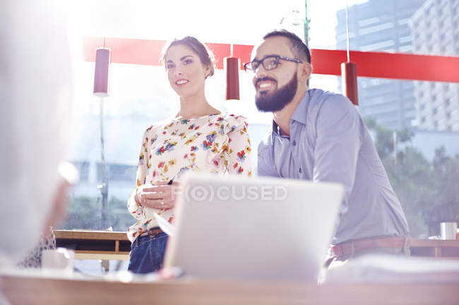 Geschäftsleute lächeln bei Treffen in modernem Café — Stockfoto