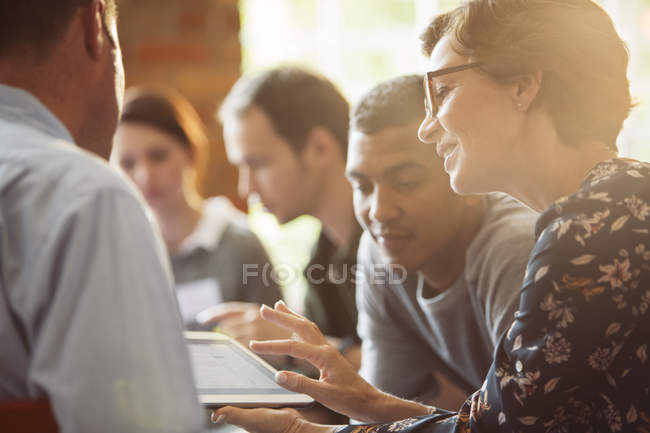 Les gens d'affaires partageant tablette numérique en réunion — Photo de stock