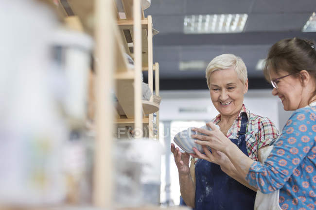Женщины осматривают чашу в мастерской керамики — стоковое фото