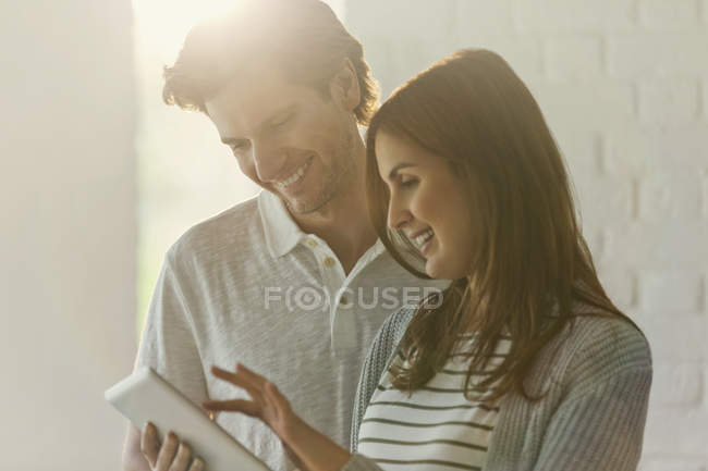 Посміхнена пара за допомогою цифрового планшета — стокове фото