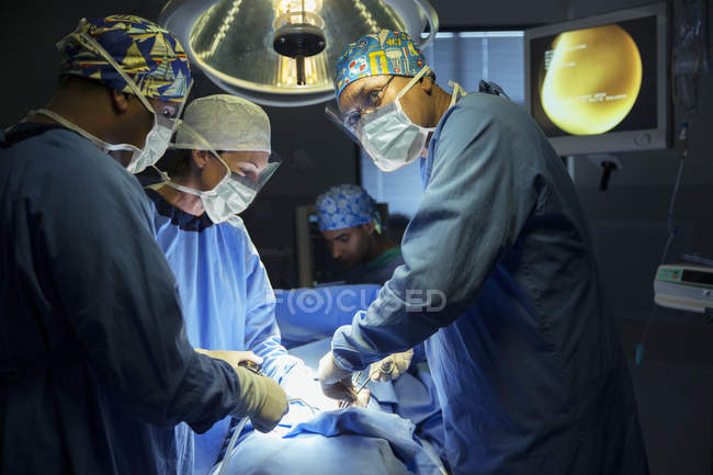 Chirurgiens opérant en salle d'opération — Photo de stock