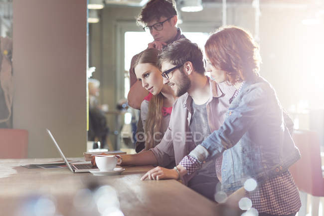 Casual business people working at laptop in sunny office — Stock Photo