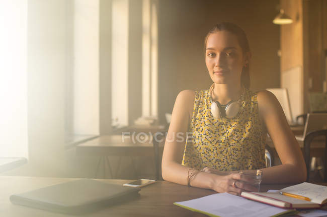 Portrait casual businesswoman with headphones working in office — Stock Photo