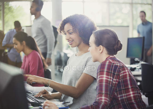 Female college students using computer at computer lab library — Stock Photo
