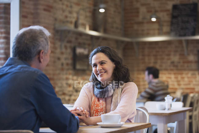 Ласковая пара, держащаяся за руки и разговаривающая в кафе — стоковое фото