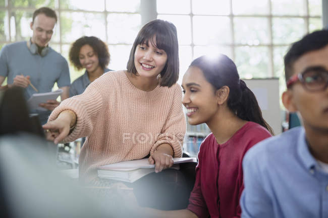 Estudiantes universitarios hablando en clase juntos - foto de stock