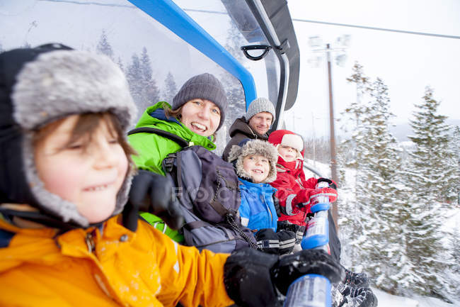 Retrato família equitação elevador de esqui — Fotografia de Stock