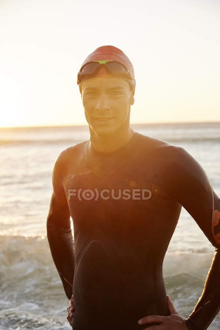 Retrato masculino triatleta nadador em terno molhado em surf oceânico — Fotografia de Stock