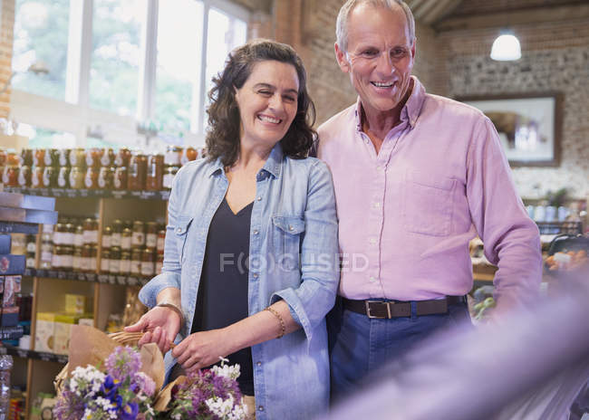 Casal sorrindo compras no mercado — Fotografia de Stock