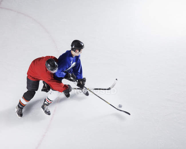 Hockey players going for puck on ice — Stock Photo