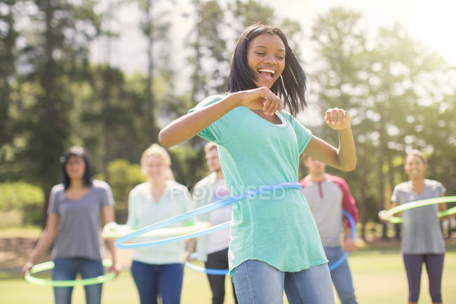 Enthusiastic woman spinning in plastic hoop — Stock Photo