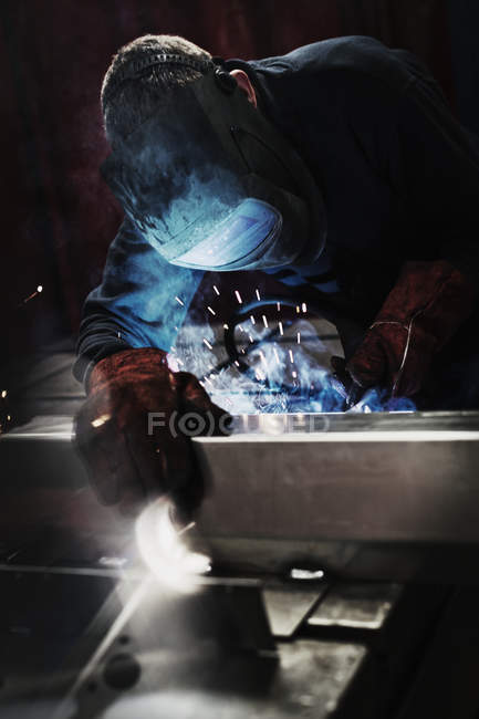 Сварщик с помощью сварочной горелки на сталелитейном заводе — стоковое фото