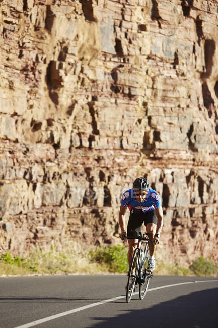 Triatleta maschile ciclista ciclista su strada soleggiata — Foto stock