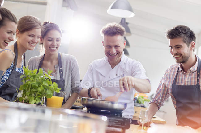 Students watching teacher in cooking class kitchen — Stock Photo