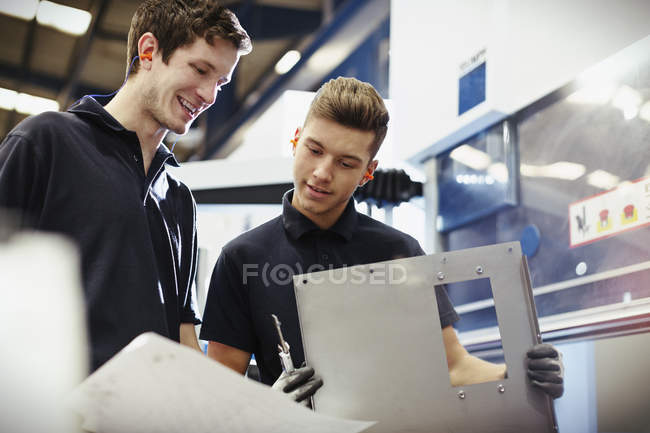 Workers reviewing paperwork in steel factory — Stock Photo