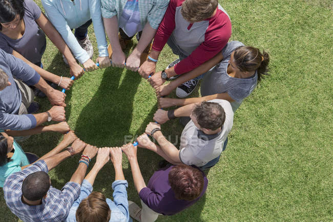 Groupe connecté en cercle autour d'un cercle en plastique — Photo de stock