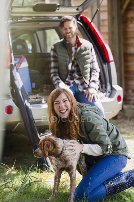 Портрет восторженная женщина с собакой снаружи автомобиля — стоковое фото