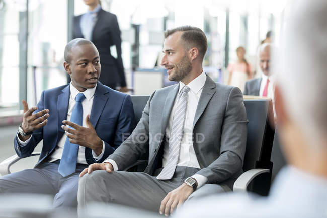 Des hommes d'affaires parlent dans la zone de départ de l'aéroport — Photo de stock